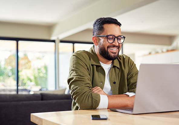 An adult man paying his bill online at home